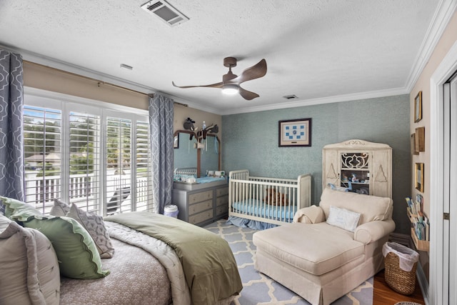 bedroom with visible vents, ornamental molding, and a textured ceiling