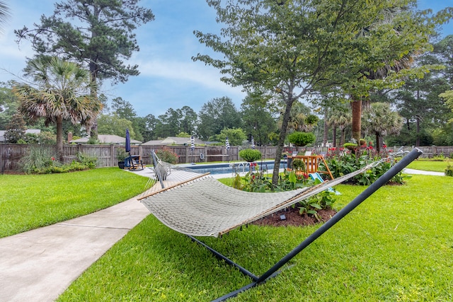 surrounding community featuring a pool, a fenced backyard, a yard, and a patio area