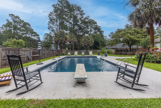 view of pool featuring a patio, a diving board, a fenced backyard, and a fenced in pool