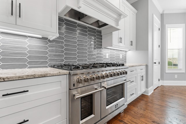3067 Rosewood Dr, Evans, GA 30809 - kitchen with range with two ovens, premium range hood, crown molding, white cabinets, and dark wood-style flooring
