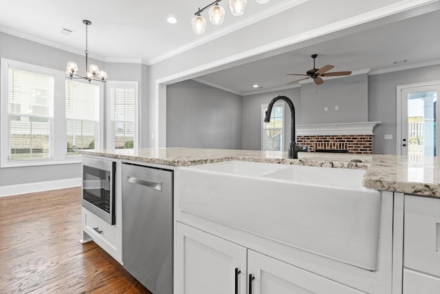 3067 Rosewood Dr, Evans, GA 30809 - kitchen with stainless steel appliances, wood finished floors, light stone counters, a brick fireplace, and recessed lighting
