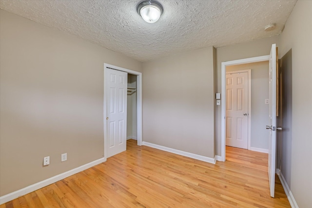 103 Adams Ln, Grovetown, GA 30813 - unfurnished bedroom featuring light wood-style floors, a textured ceiling, and a closet