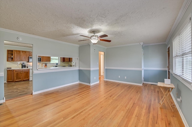 103 Adams Ln, Grovetown, GA 30813 - unfurnished living room featuring light wood-style flooring, ceiling fan, plenty of natural light, a textured ceiling, and ornamental molding