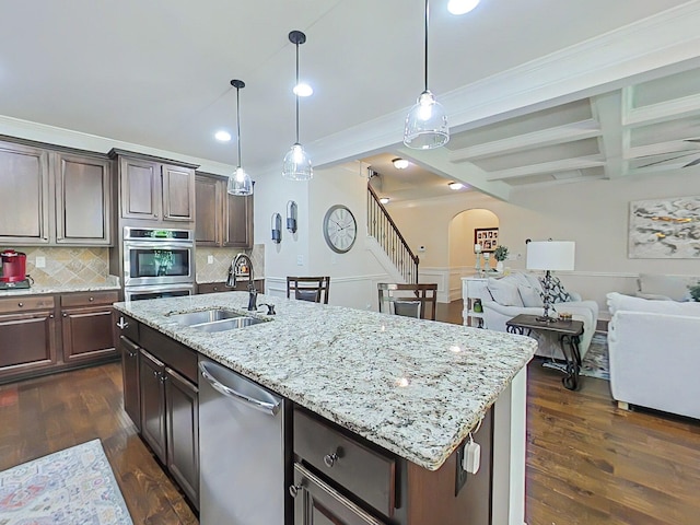 1038 Dietrich Ln, North Augusta, SC 29860 - kitchen featuring stainless steel appliances, a sink, arched walkways, decorative backsplash, and open floor plan