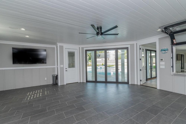 unfurnished living room with ceiling fan and crown molding