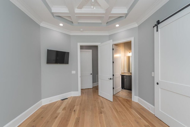 unfurnished bedroom with beam ceiling, coffered ceiling, a barn door, light hardwood / wood-style flooring, and crown molding