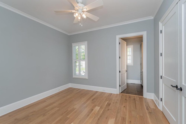 empty room with light hardwood / wood-style floors, ceiling fan, and crown molding