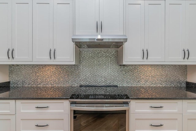 kitchen with white cabinets, stainless steel electric range oven, dark stone counters, and tasteful backsplash