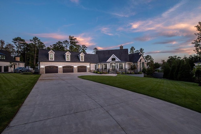 new england style home with a lawn and a garage