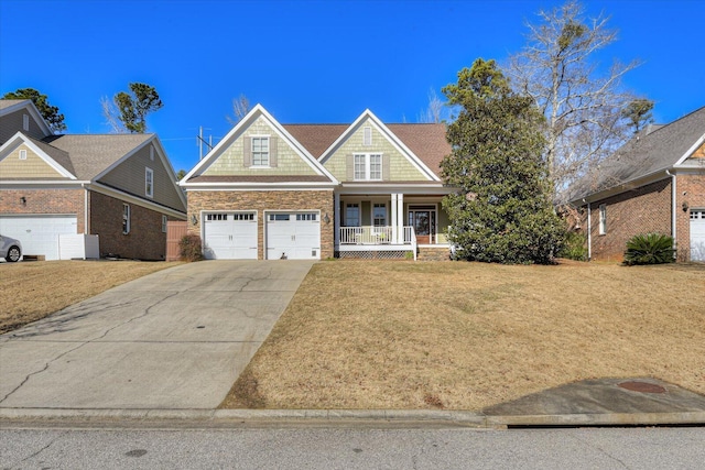 craftsman-style home with a garage, concrete driveway, stone siding, a porch, and a front yard