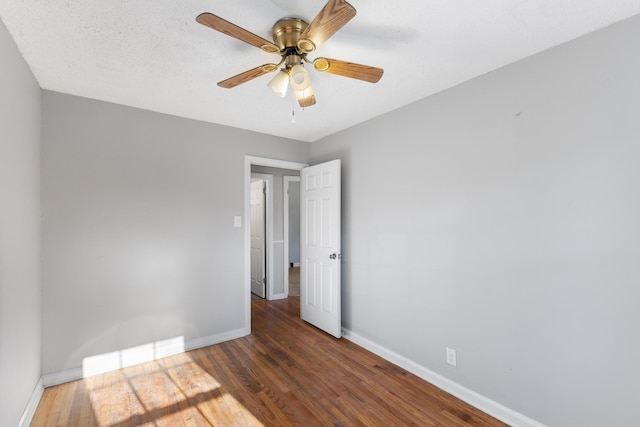 unfurnished room featuring ceiling fan, a textured ceiling, baseboards, and wood finished floors