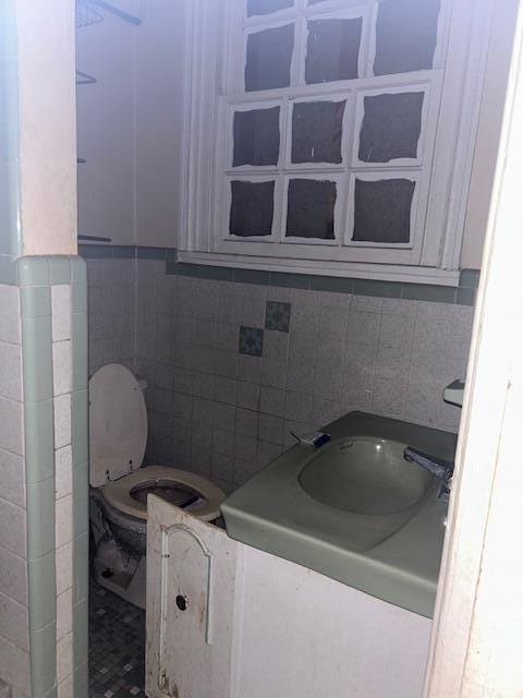 1620 12th St, Augusta, GA 30901 - bathroom with tile walls, toilet, and backsplash