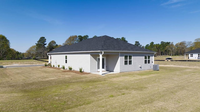 view of front of house featuring a front yard and central air condition unit