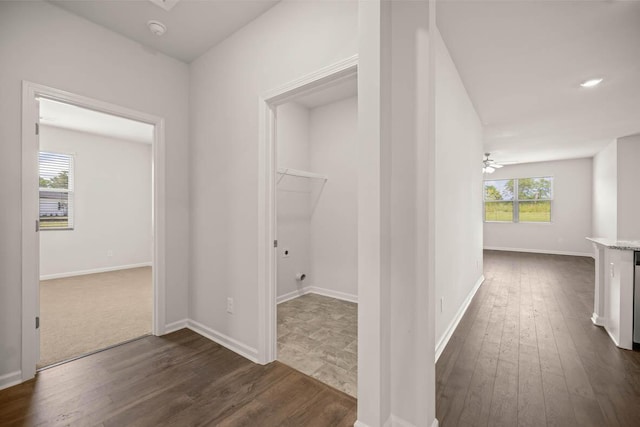 hallway featuring dark wood-type flooring and baseboards