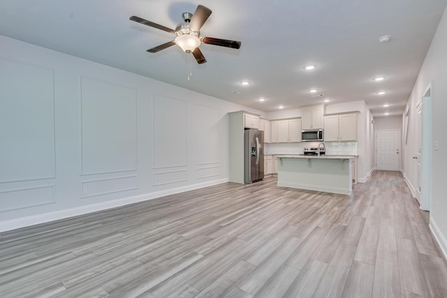 1056 Candleberry Dr, Grovetown, GA 30813 - kitchen with stainless steel appliances, open floor plan, light countertops, a kitchen breakfast bar, and ceiling fan
