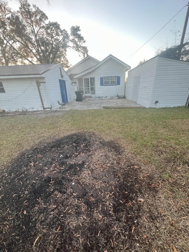 back of property with a patio area and a yard