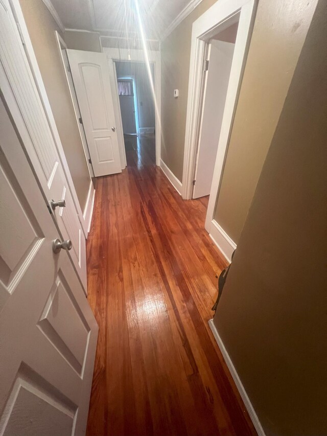 hall with hardwood / wood-style flooring and ornamental molding