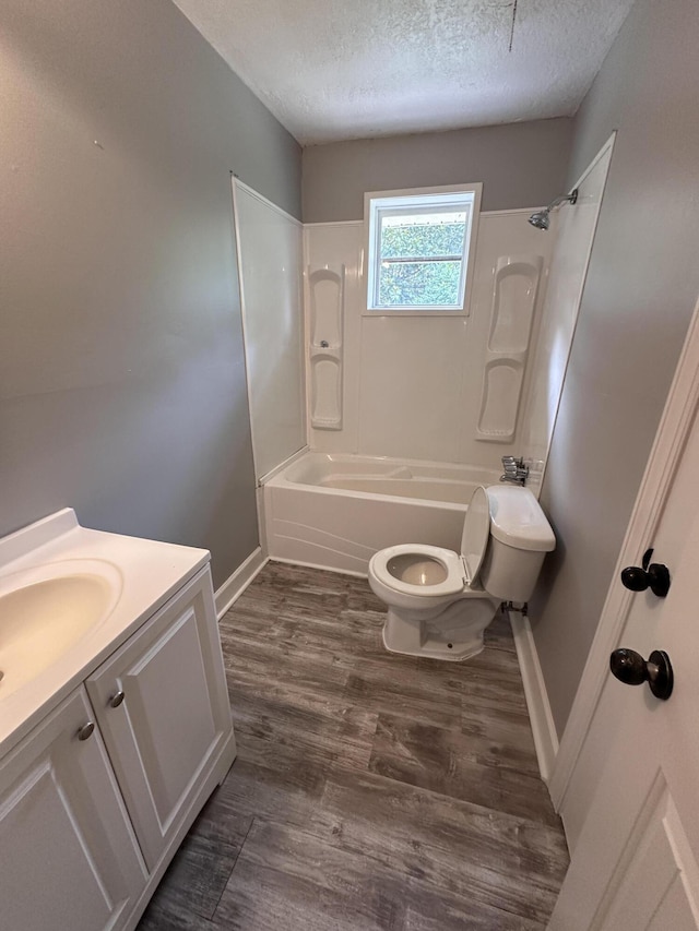 full bathroom featuring a textured ceiling, toilet, vanity, bathtub / shower combination, and hardwood / wood-style flooring