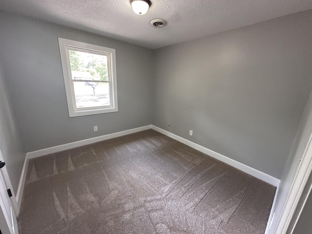 carpeted spare room featuring a textured ceiling