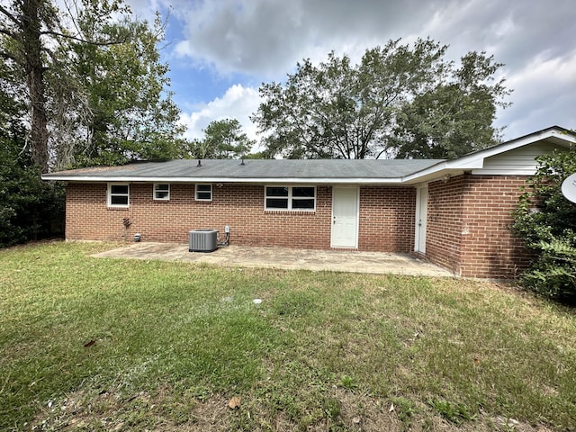 rear view of house with a lawn, a patio area, and central AC