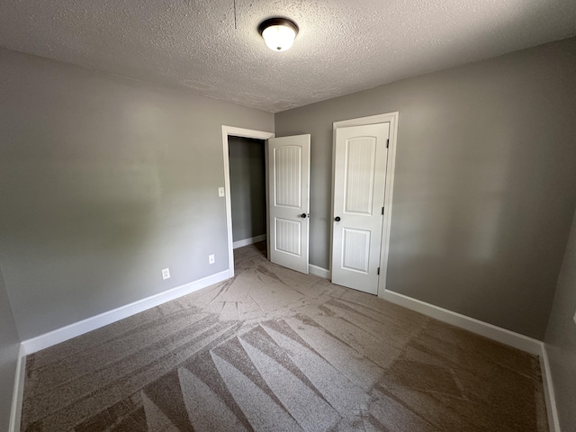 unfurnished bedroom with carpet flooring and a textured ceiling