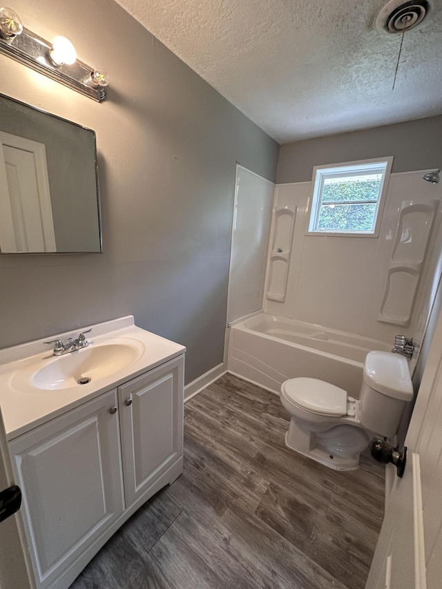 full bathroom featuring shower / washtub combination, vanity, hardwood / wood-style floors, and a textured ceiling