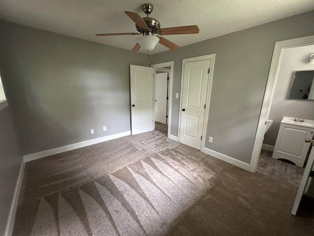 unfurnished bedroom with ensuite bath, ceiling fan, and carpet floors