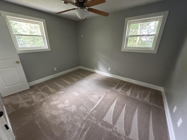 carpeted spare room featuring ceiling fan