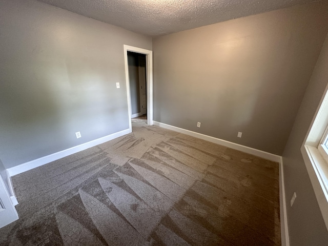 carpeted spare room featuring a textured ceiling