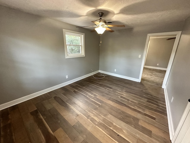 empty room with a textured ceiling, ceiling fan, and dark hardwood / wood-style floors