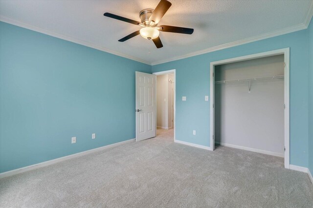 unfurnished bedroom featuring light carpet, a closet, ceiling fan, and ornamental molding