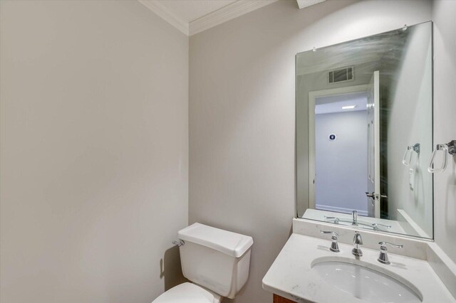 bathroom featuring toilet, vanity, and ornamental molding