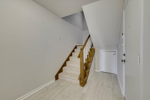 stairs with a textured ceiling