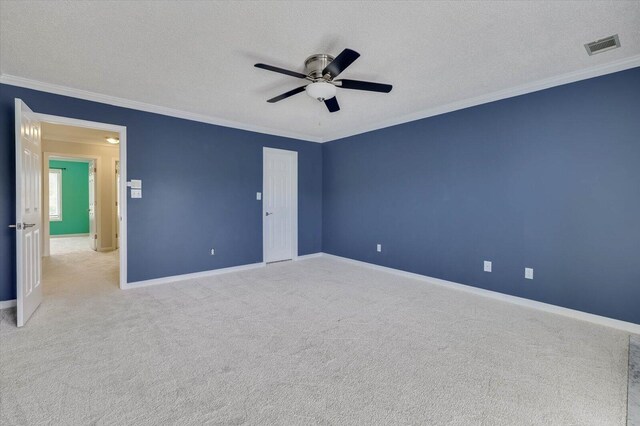 unfurnished bedroom with a textured ceiling, ceiling fan, crown molding, and light carpet