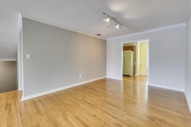 unfurnished room featuring track lighting, ornamental molding, a textured ceiling, and light hardwood / wood-style flooring