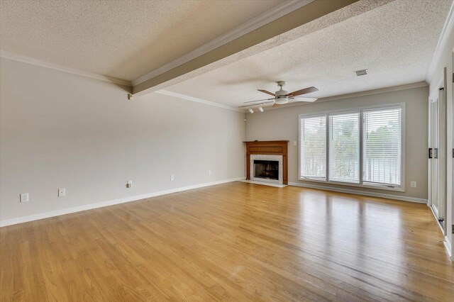 unfurnished living room featuring ceiling fan, light wood-type flooring, a textured ceiling, and ornamental molding