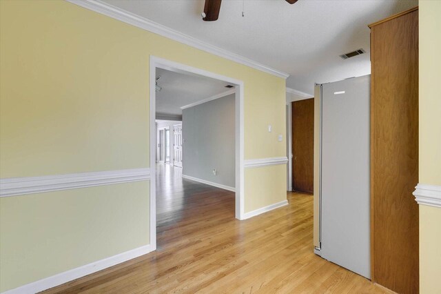 unfurnished room featuring ceiling fan, light hardwood / wood-style floors, and ornamental molding