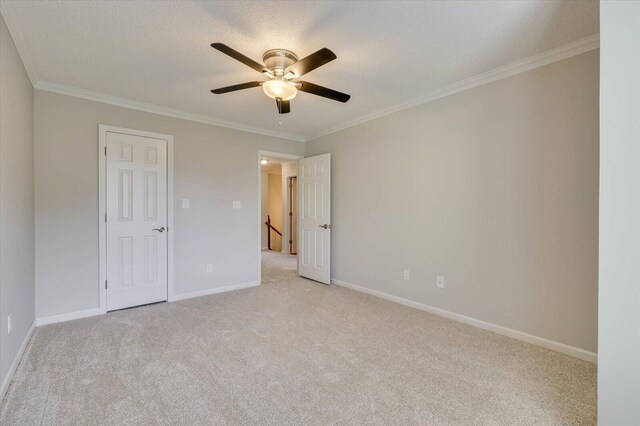 unfurnished bedroom featuring ceiling fan, light colored carpet, and crown molding