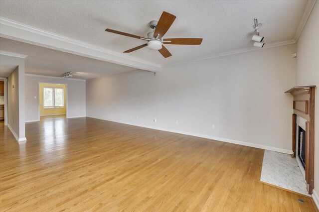 unfurnished living room featuring ceiling fan, crown molding, a textured ceiling, and light hardwood / wood-style flooring