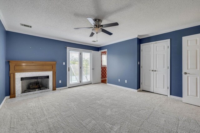 unfurnished living room featuring crown molding, ceiling fan, light carpet, and a textured ceiling