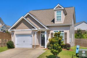 view of front of home with a garage, concrete driveway, a front lawn, and fence