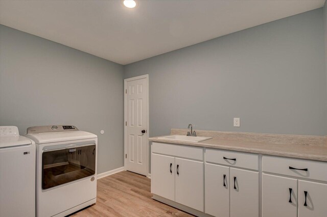 washroom with cabinets, separate washer and dryer, sink, and light wood-type flooring