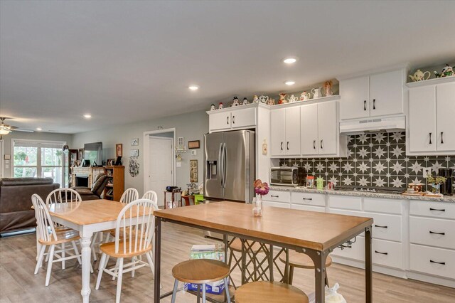 kitchen with ceiling fan, decorative backsplash, custom range hood, appliances with stainless steel finishes, and white cabinetry