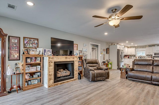 living room featuring light hardwood / wood-style floors and ceiling fan