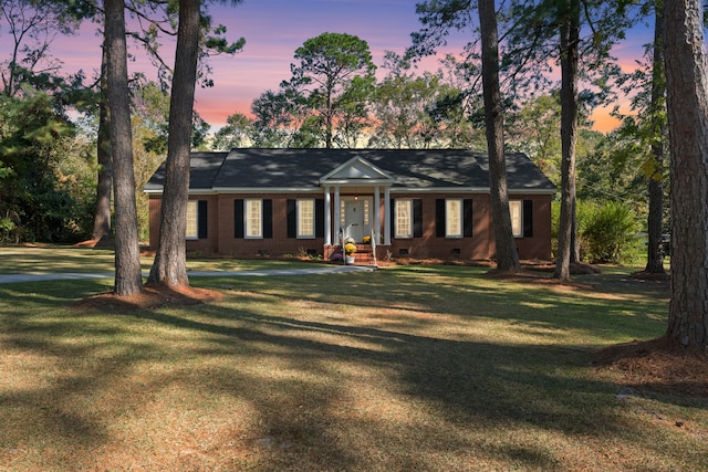 ranch-style home featuring a lawn