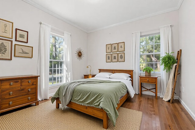 bedroom with crown molding, dark hardwood / wood-style floors, and multiple windows