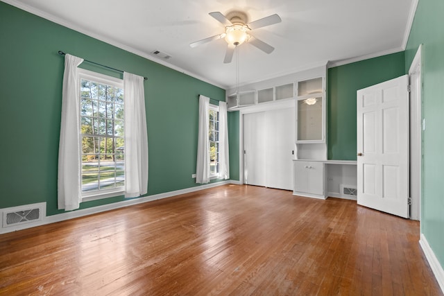 unfurnished bedroom with hardwood / wood-style flooring, ornamental molding, and ceiling fan