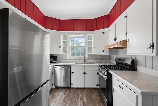 kitchen featuring dark wood-type flooring, sink, crown molding, appliances with stainless steel finishes, and white cabinets