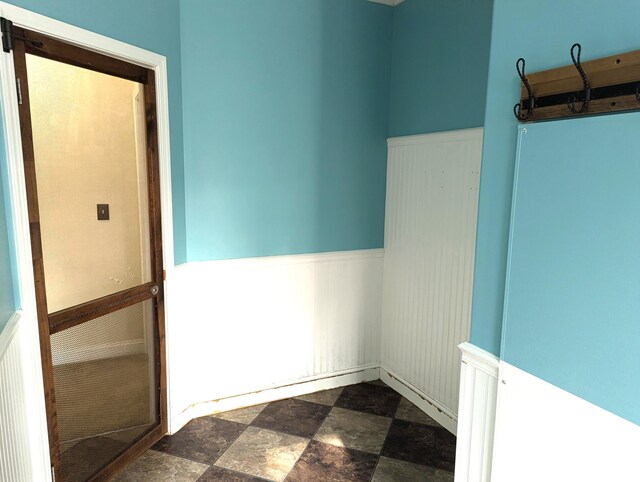 unfurnished room with wainscoting