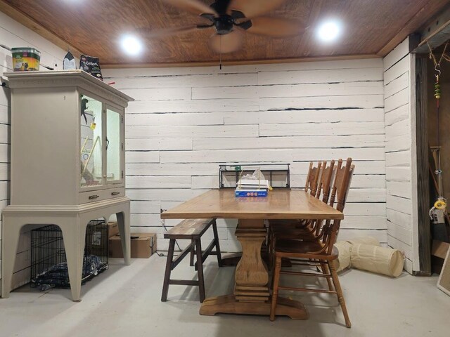 dining space with wood ceiling, wooden walls, and finished concrete floors